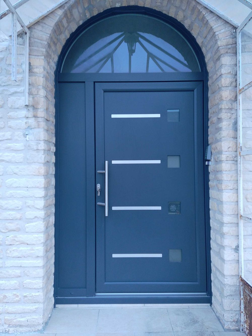 Porte d'entrée avec imposte cintrée sur arche pierre